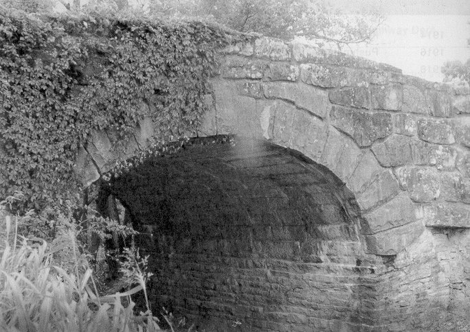 Bridge 4314 0270 X, a stone arch dating from 1918, stands on a scenic road along the west side of Lake Murray in Love County.